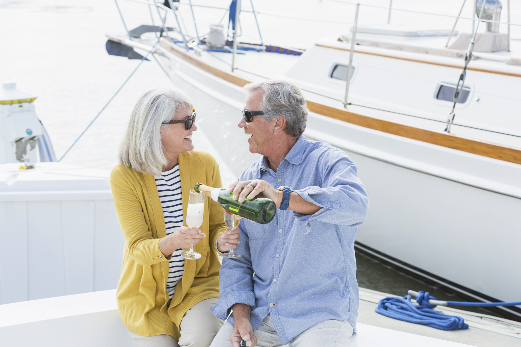 Senior couple on boat celebrating with champagne – True North Marine