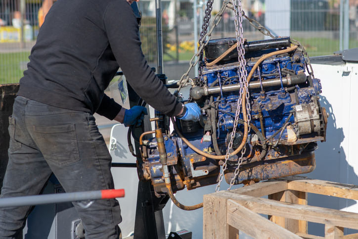 man moving blue engine block